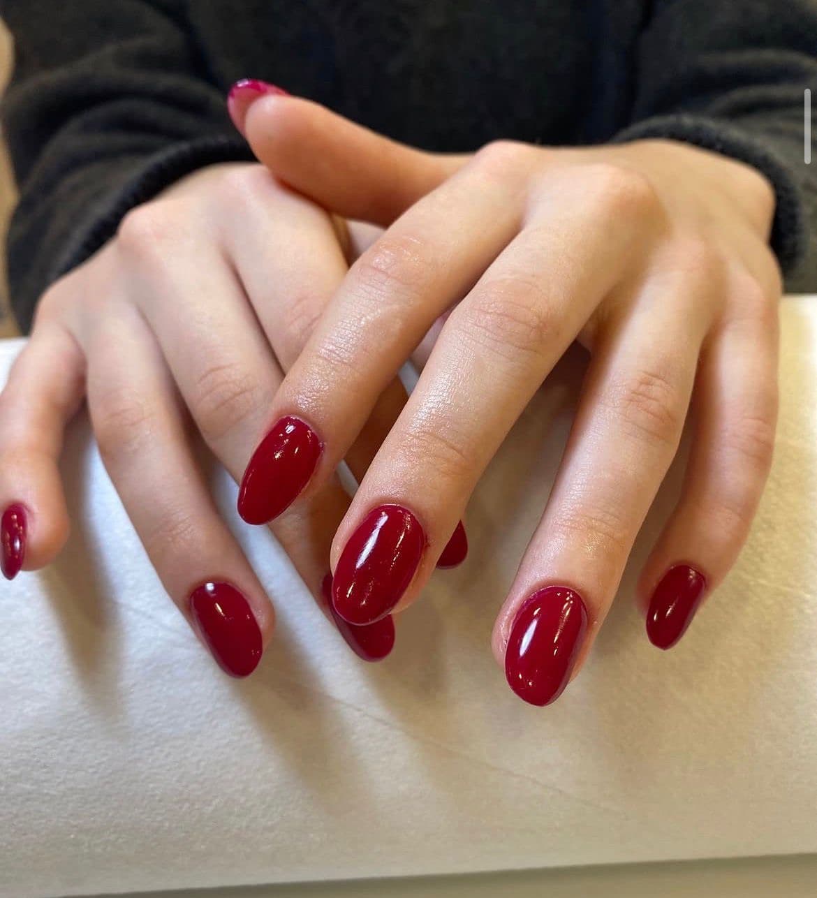 Manicura semipermanente rojo cereza con acabado brillante y forma ovalada